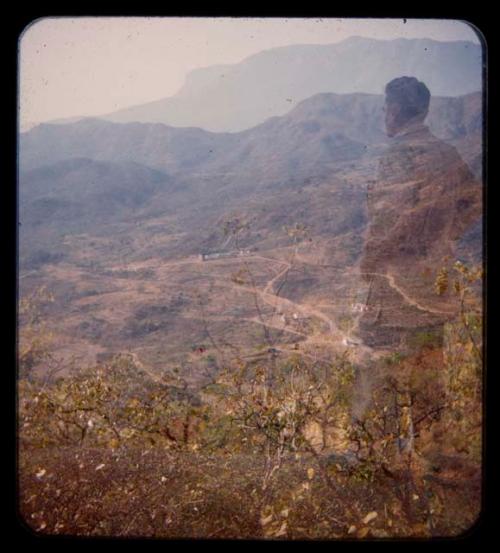 Expedition member standing, valley (double exposure)