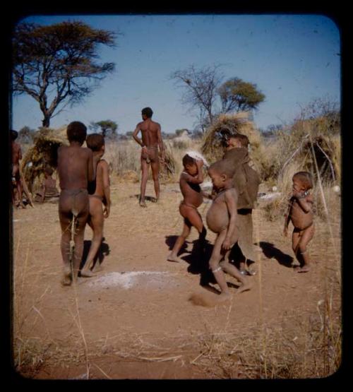 /Gishay, Tsamgao, N!aishi, N!ai, N/ani and /Gaishay dancing, with "Gao Medicine" standing in the background