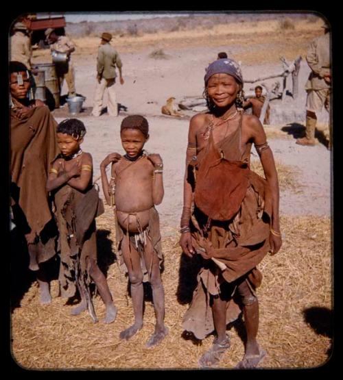 Two women standing, one wearing Elizabeth Marshall Thomas' scarf on her head, with two children standing next to them