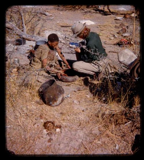 Woman preparing blood in a bowl, with Lorna Marshall taking notes