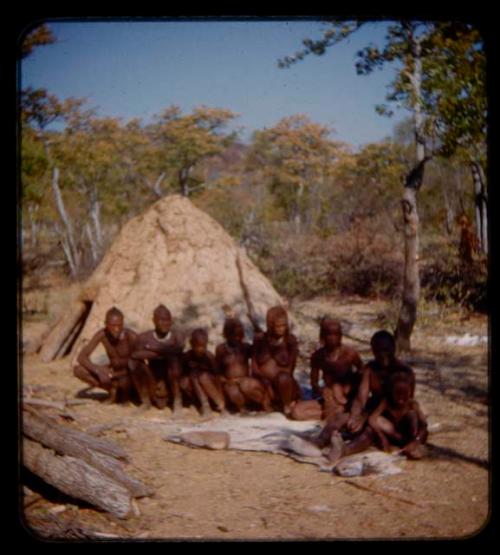 Meri Catinga sitting with his family in front of a hut, including Cauripé, Tschissungo, Tchime, Catchecucere, Muitohem and his wife, Pirululu