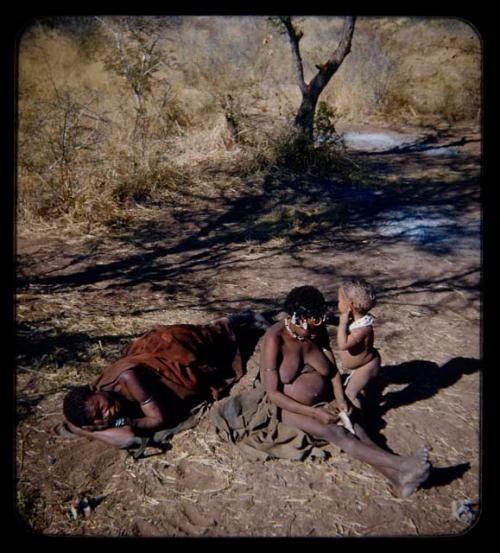 Children, Mothers nursing babies: ≠Toma's sister sitting and her child standing, with an elderly woman wrapped in kaross lying on the ground nearby