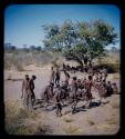 Dance: Group of men performing a curing dance around seated women