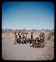 Dance: Group of men performing a curing dance around seated women