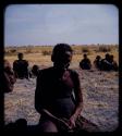 Portraits: Elderly man sitting, with other people sitting in the background