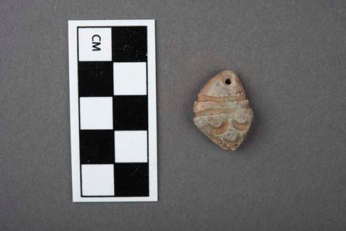 Carved stone pendant, human face