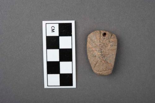 Carved stone pendant, human face