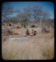 Skerm: Man, a woman, and two children sitting on a white animal hide in front of skerms