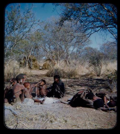 Sleep: Group of people sitting near ashes, with other people wrapped in karosses sleeping nearby