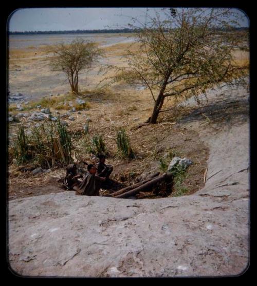 Waterhole: Three people sitting at a waterhole