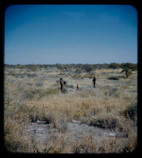 Water: Man carrying a pot on stick over his shoulder, followed by a child and another man with ostrich eggshell