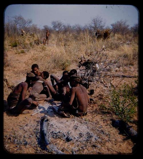 "Young Men": Group of men gathered around fire