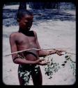 "Young Men": Boy holding a tree branch with his hands