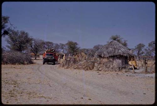 Expedition trucks driving into a village