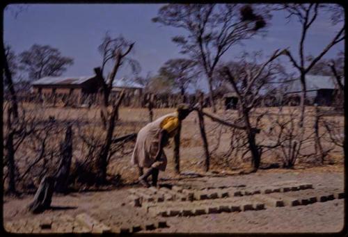 Woman making bricks (out of focus)