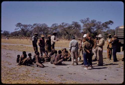 Group visiting expedition members standing by the expedition trucks