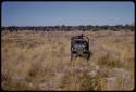 Expedition truck driving through a grass field