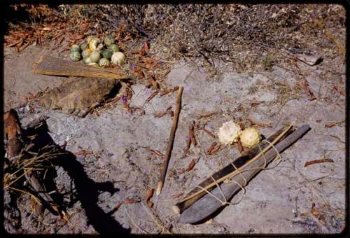 Piles of tsama melons, bows, arrows, and cloth on the ground