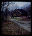 Lorna Marshall and another woman standing in front of a house, distant view