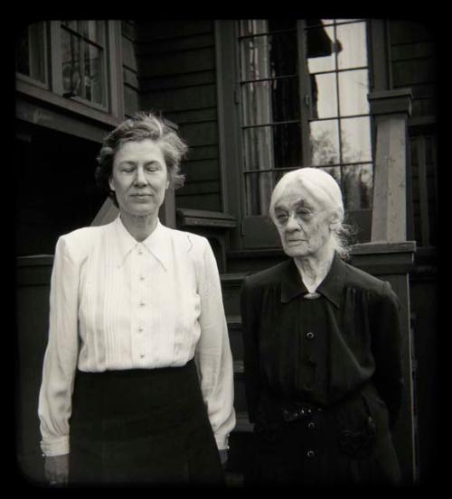 Lorna Marshall standing with another woman in front of a house