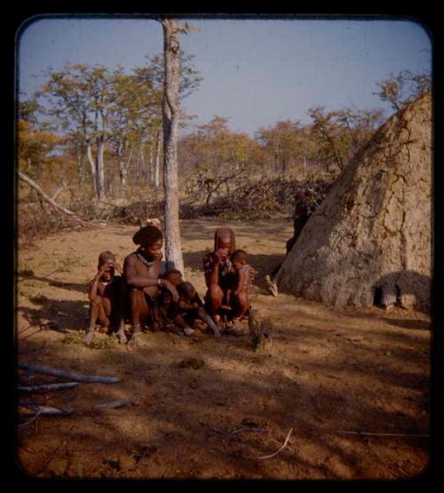 Coutimwe and Sambim sitting with four children in front of a hut