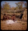 Kanakele and Capepe sitting with three children in front of a hut