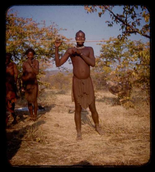 Tchissungo standing, playing a musical bow