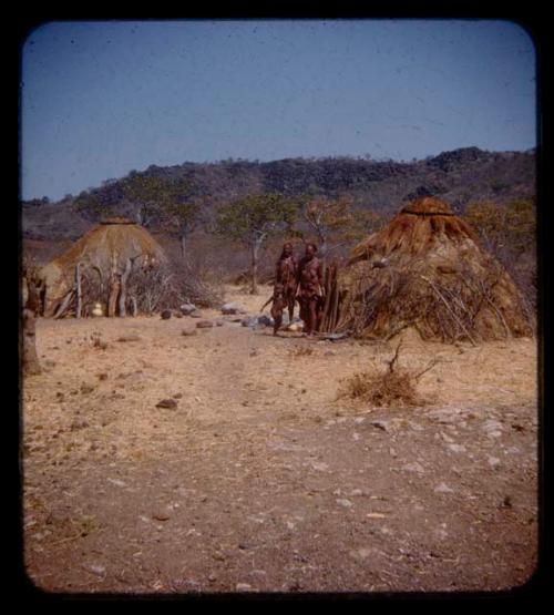 Tcheholola's aunt standing with an unidentified woman and a child in front of Tcheholola's hut