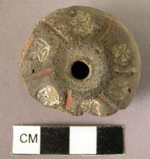 Pottery spindle whorl with stamped and colored designs - piece shipped off