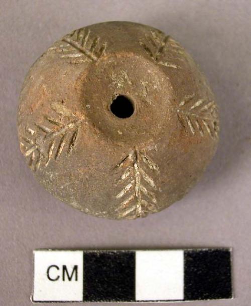 Pottery spindle whorl with incised and designs