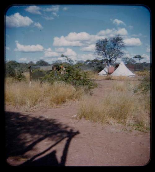 Expedition: Distant view of tents, with blankets hanging on a line nearby