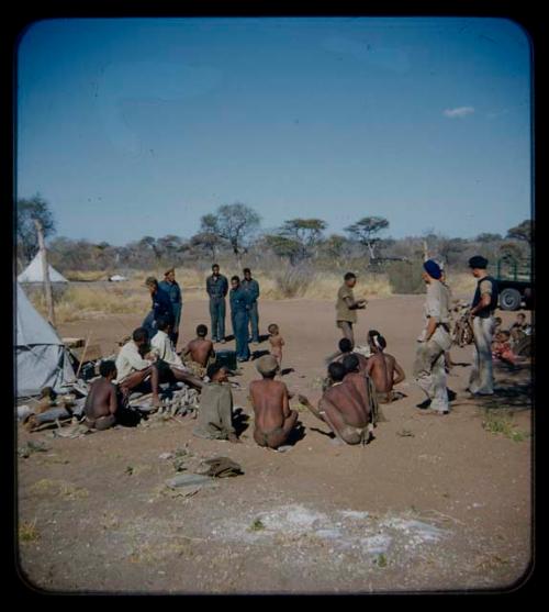 Expedition: Group of people sitting and expedition members standing near them