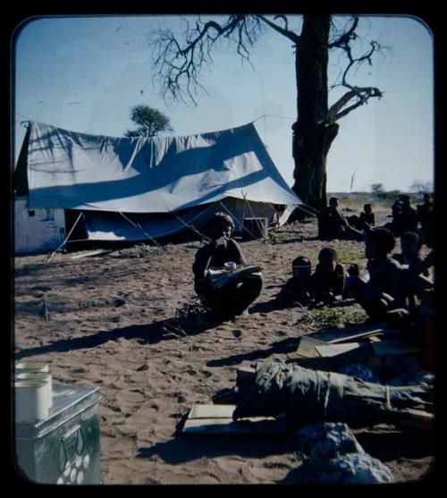 Expedition: Group of people gathered, with a tent in the background