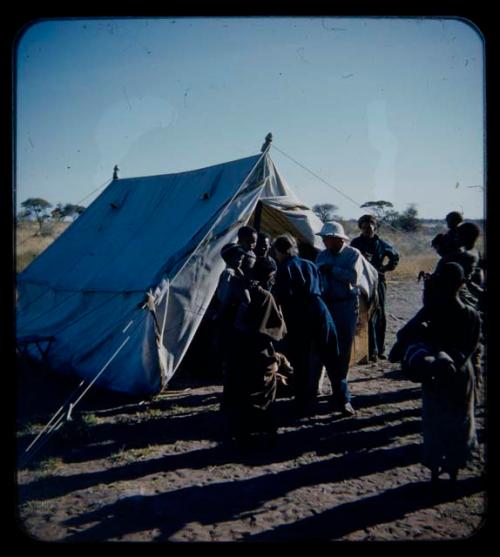 Expedition: Laurence Marshall and Lorna Marshall probably handing out gifts to a group of people in front of a tent