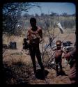 Expedition: Man standing and holding a hat that contains something, with a boy standing next to him