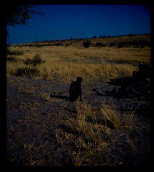 Expedition: Man squatting on the ground, seen from behind