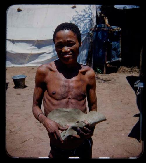 Expedition: Man holding a hat in his hands, with a tent in the background