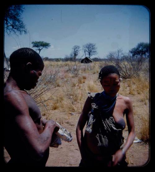 Expedition: Man and woman standing, with a tent in the background