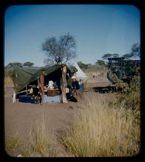 Expedition: Lorna Marshall and two men at a tape-recording session, with record sound equipment nearby