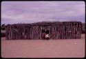 Teacher standing outside a tanning shed used as an auxiliary classroom by a school