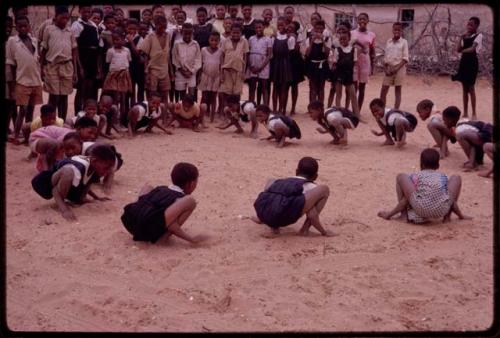 Girls imitating frogs at recess at a school