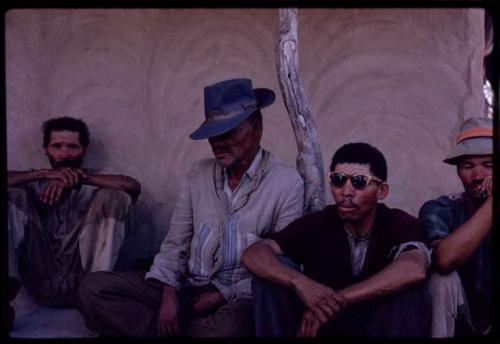 Brother of a leader of a group from Johannesburg (wearing a hat) sitting with other people on a porch