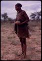 Woman standing, holding a water root