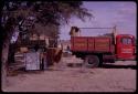 Refrigerator and drums next to an expedition truck (Dodge) in camp