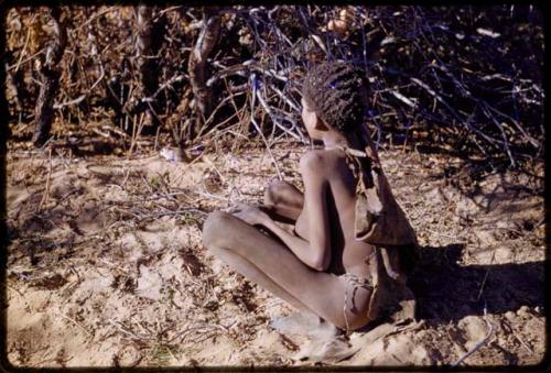 Boy sitting in sand, seen from behind