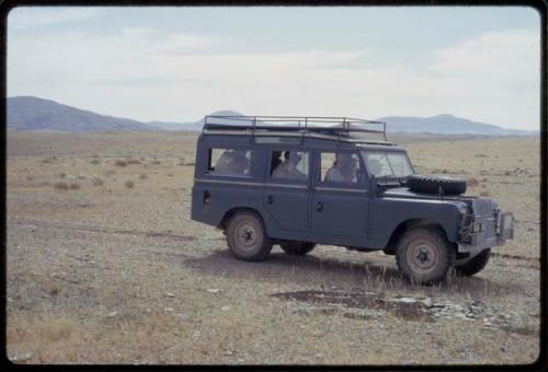 Expedition Land Rover parked, people sitting inside