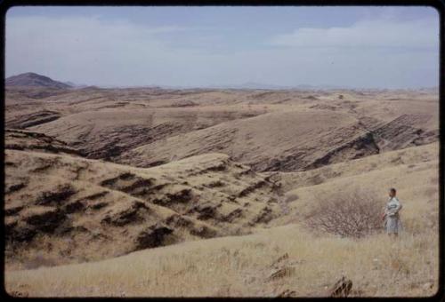 Landscape of rocks and hills, Leslie McIntyre standing to the side