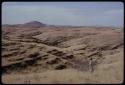 Landscape of rocks and hills, Leslie McIntyre standing to the side