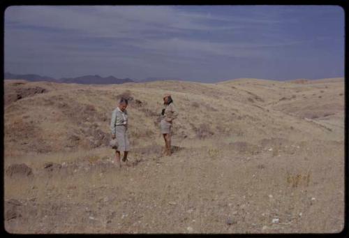 Lorna Marshall and O.P.M. Prozesky standing on rocky yellow grassland