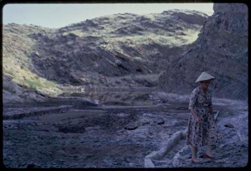 Woman walking, water reservoir in the background